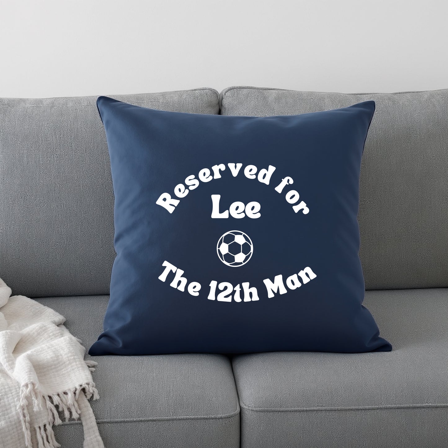 Blue cushion with personalisation and a football graphic on a grey sofa
