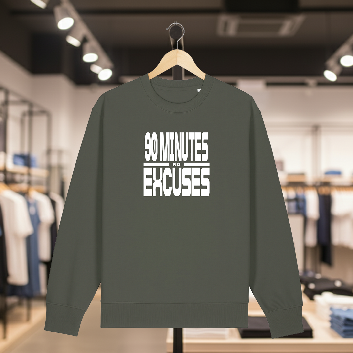 Khaki sweatshirt with 90 MINUTES NO EXCUSES text on a hanger in a store setting