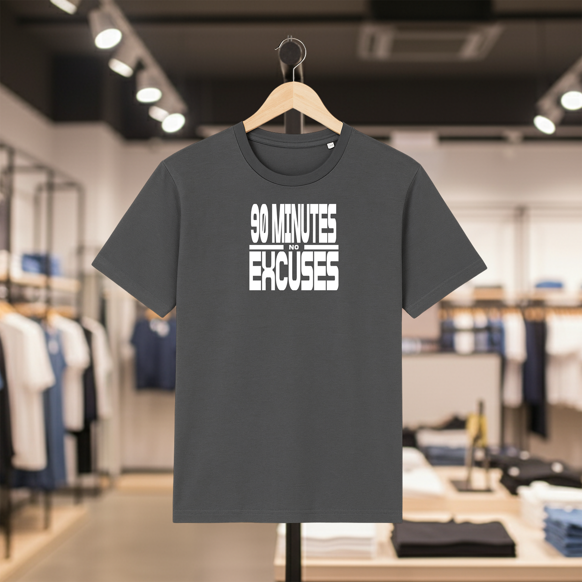 Greyt-shirt with '90 Minutes No Excuses' text on a hanger in a clothing store.