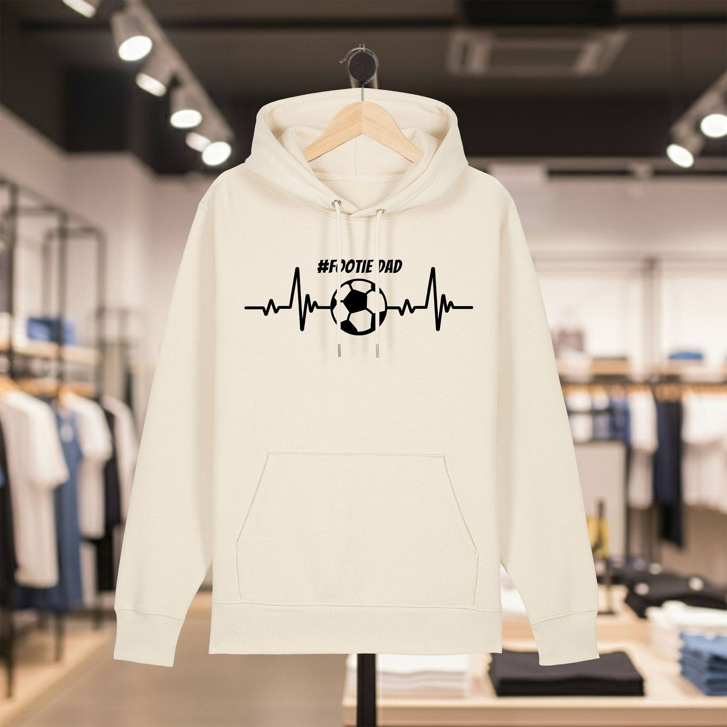 Natural hoodie with white text #FOOTIE DAD on a hanger in a store setting