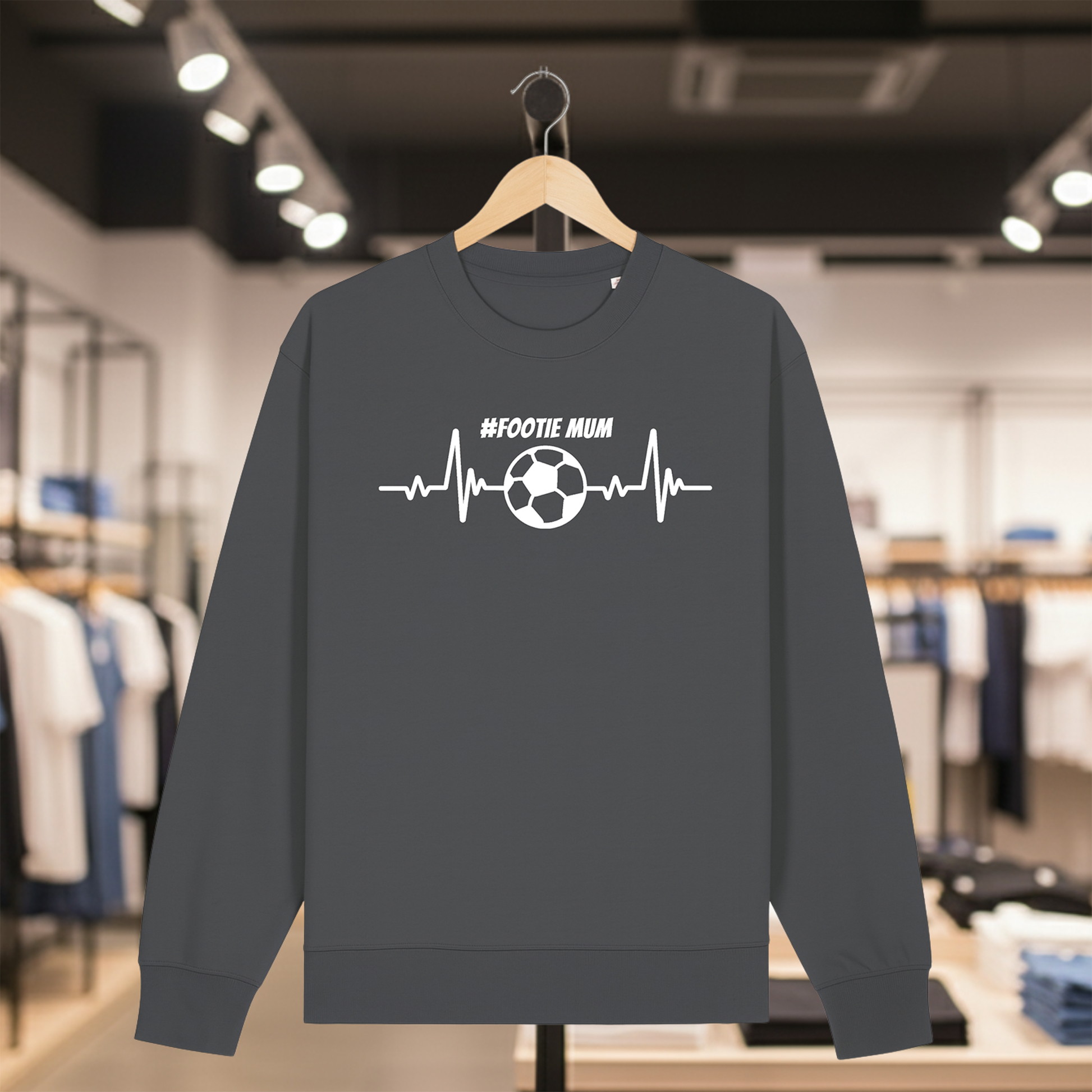 Grey sweatshirt with a white #FOOTIE MUM text on a hanger in a store setting