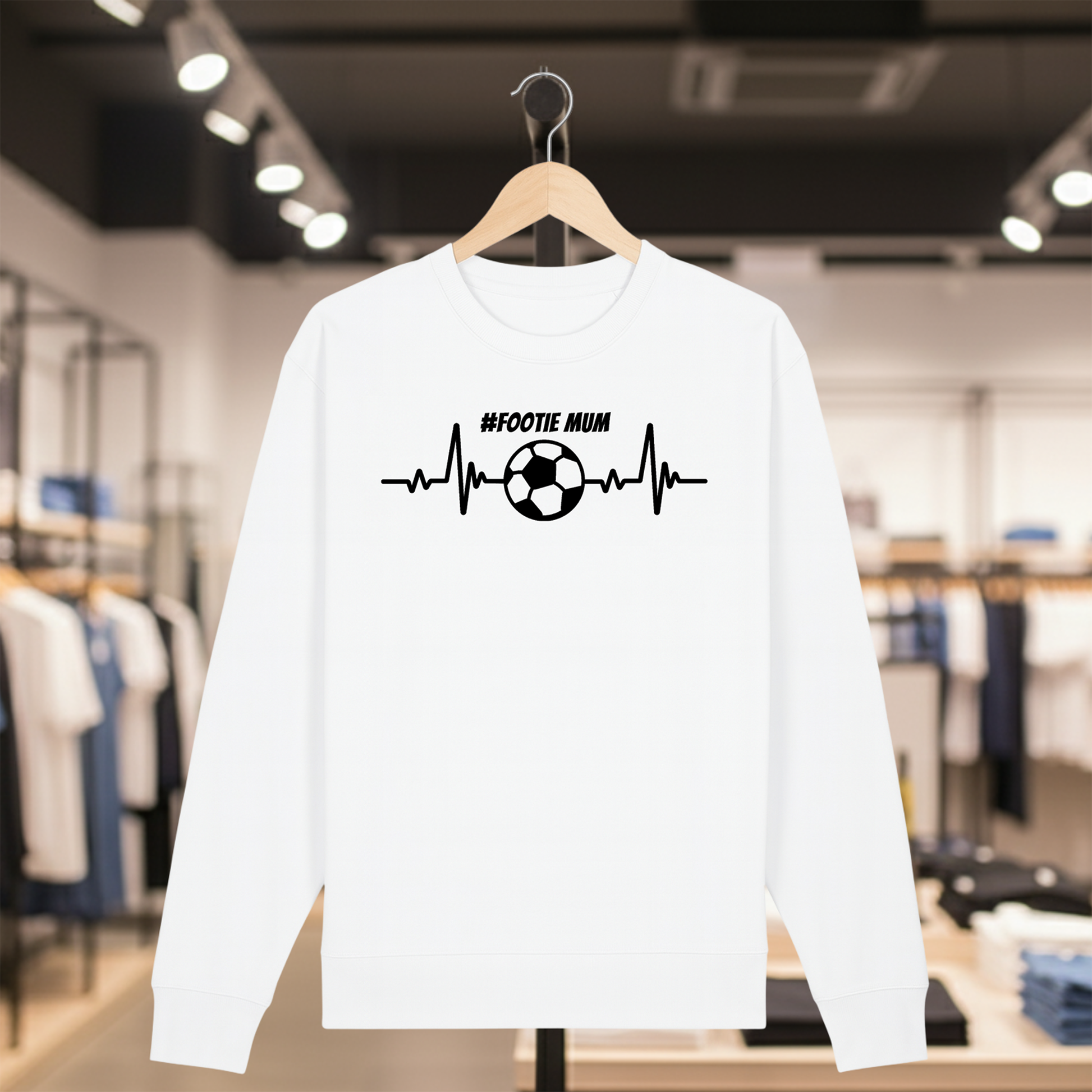 White sweatshirt with a white #FOOTIE MUM text on a hanger in a store setting