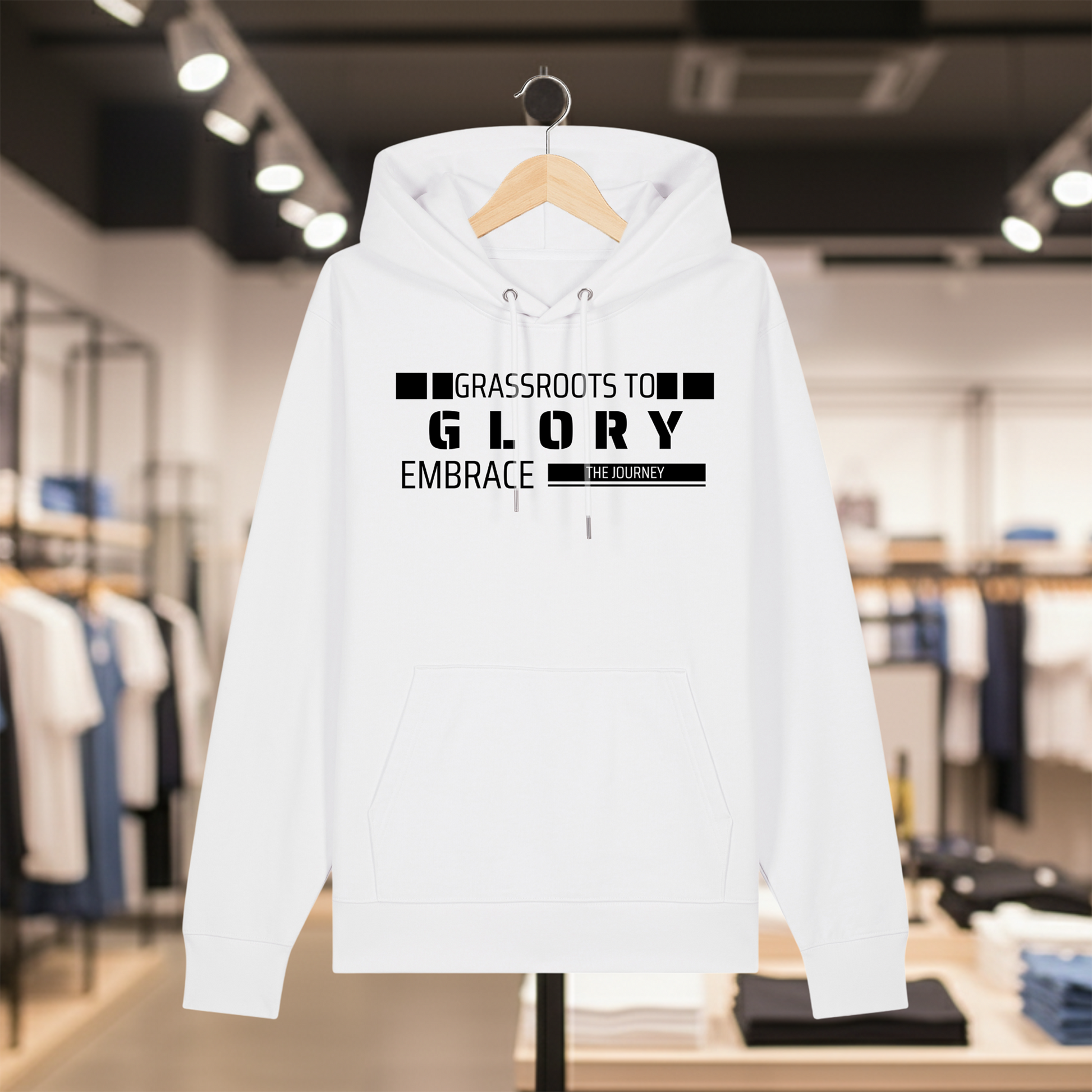 White hoodie with text GRASSROOTS TO GLORY on a hanger in a store setting