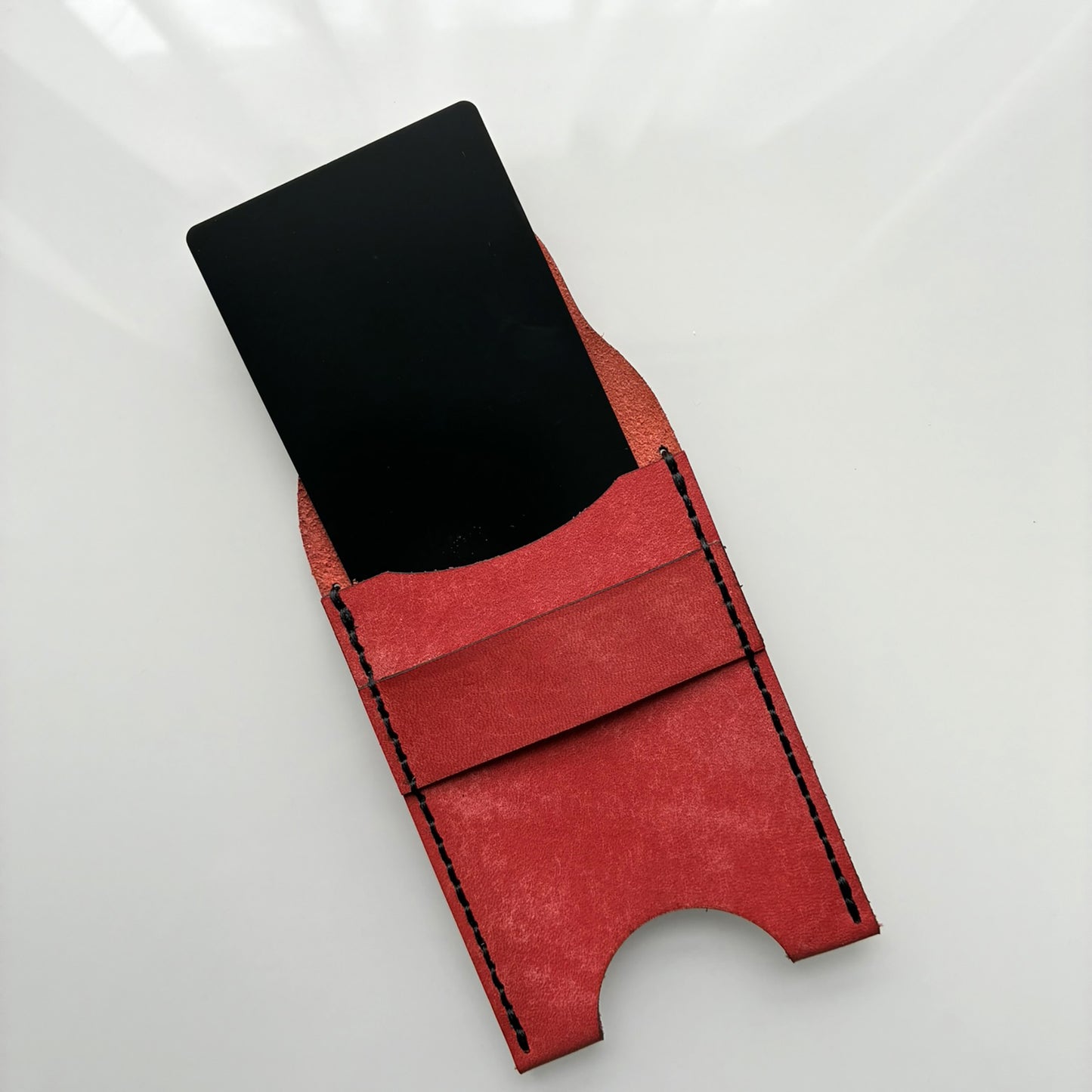 Red leather wallet on a white background showing how to insert a bank card