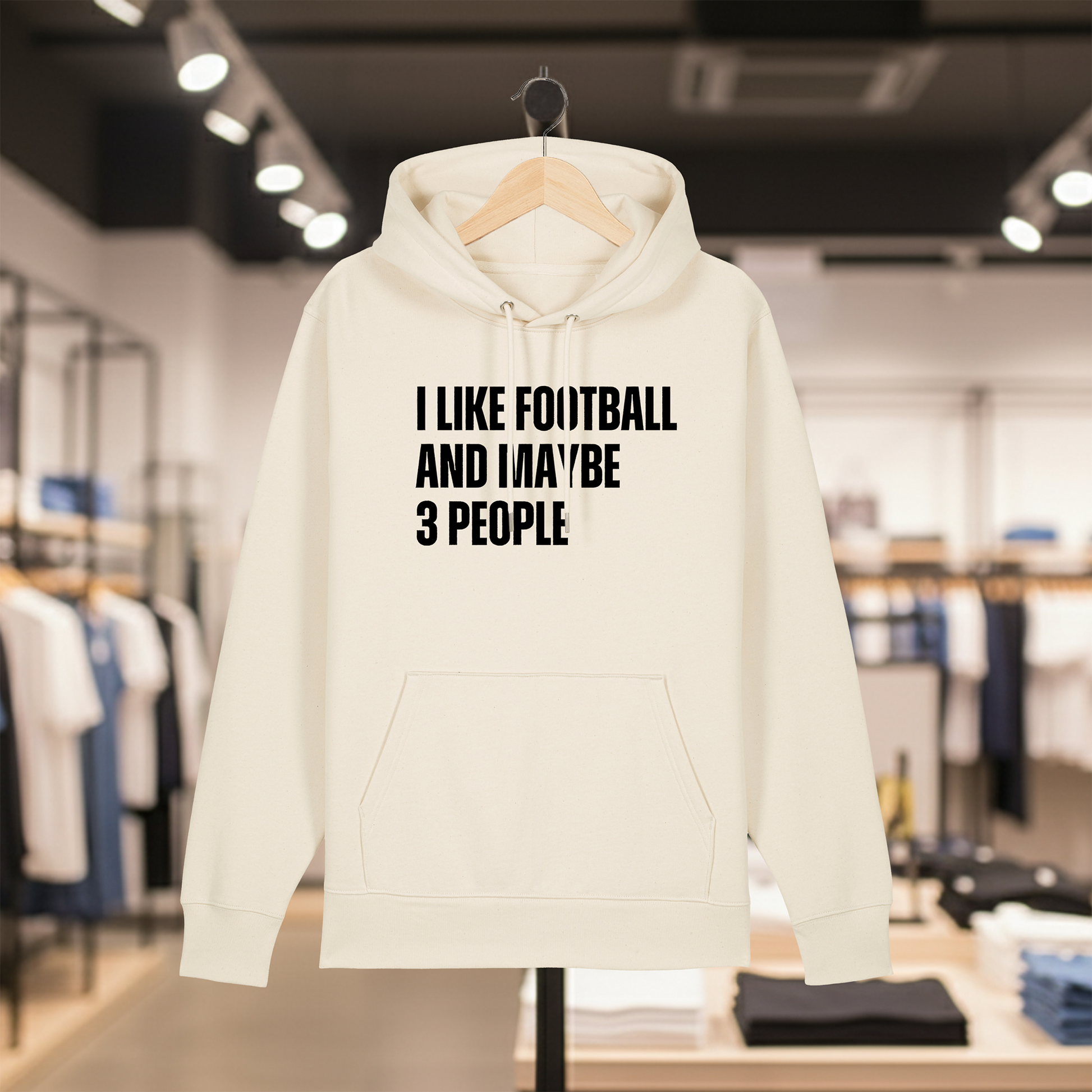 Natural hoodie with text I LIKE FOOTBALL AND MAYBE 3 PEOPLE on a hanger in a store setting.