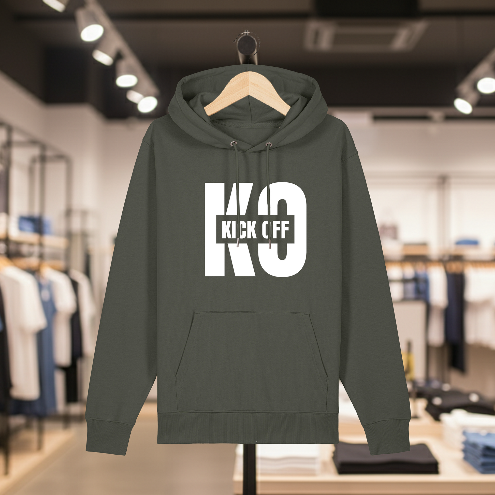 Khaki hoodie with white text KICK OFF on a hanger in a store setting