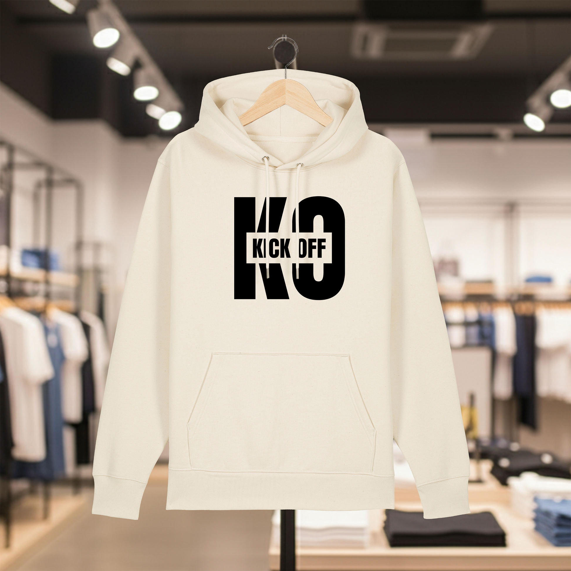 Natural hoodie with white text KICK OFF on a hanger in a store setting