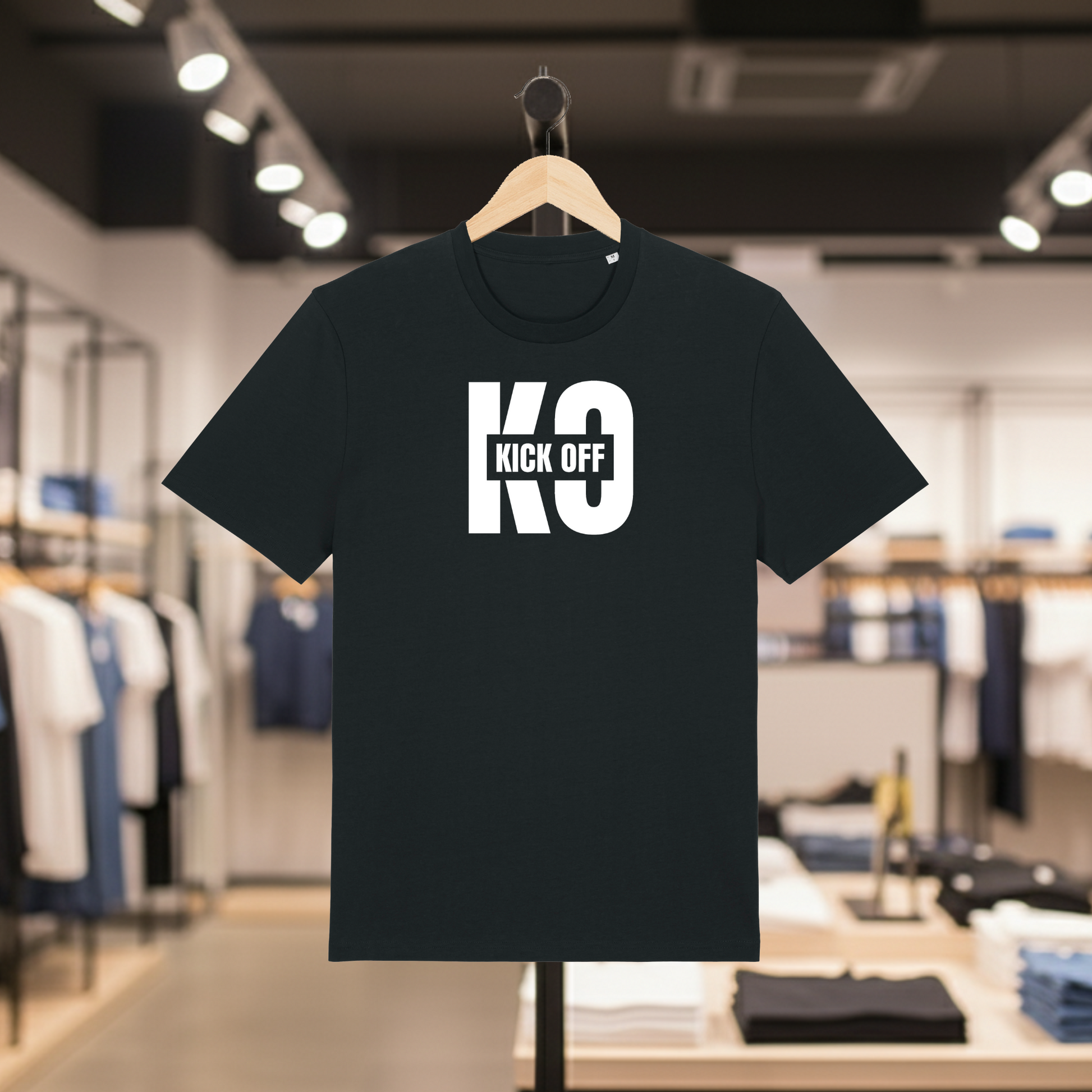 Black t-shirt with KICK OFF text on a hanger in a store setting