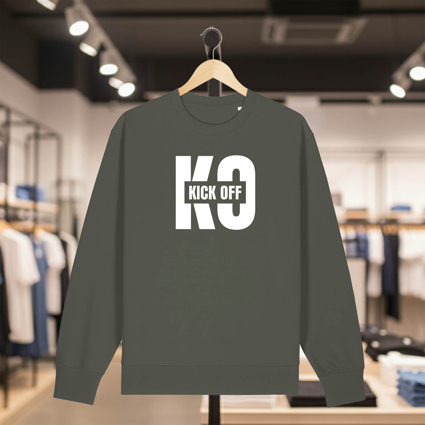 Khaki sweatshirt with KICK OFF text on a hanger in a store setting