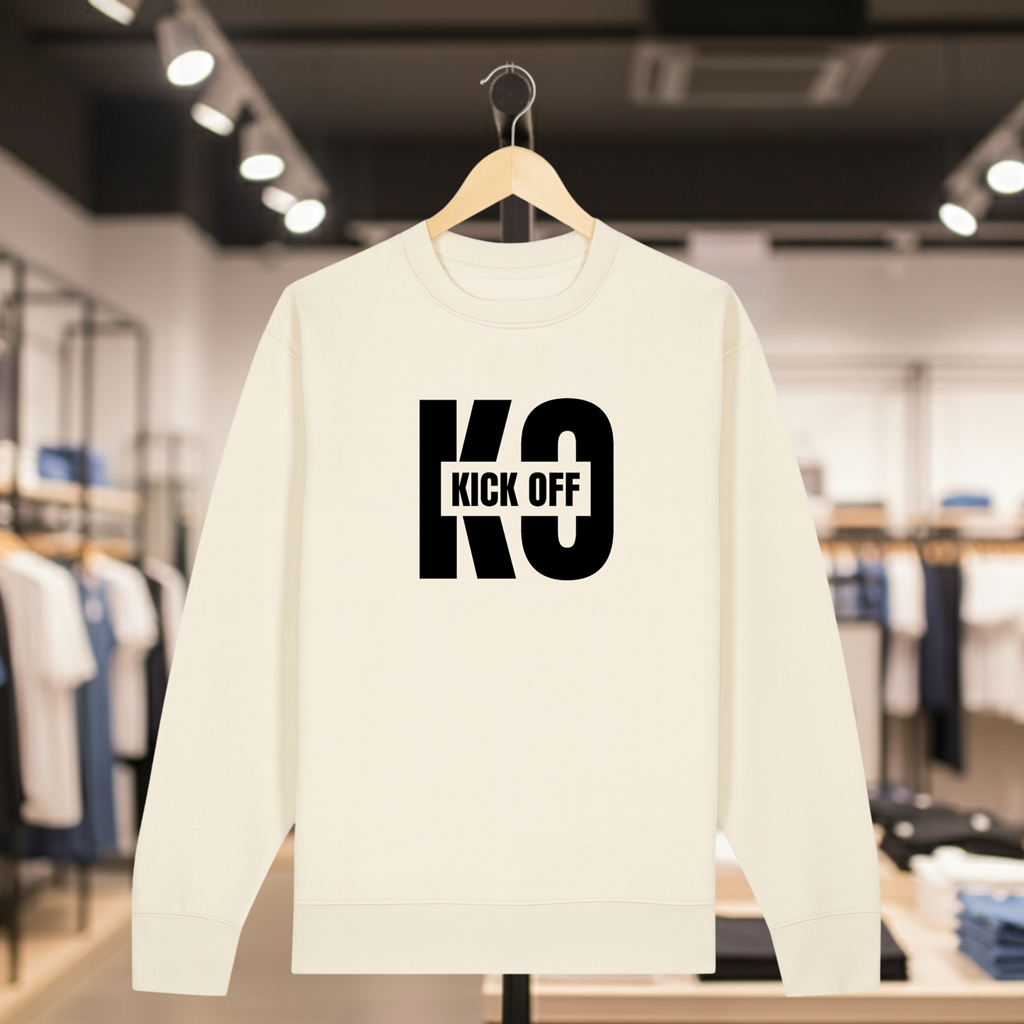 Natural sweatshirt with KICK OFF text on a hanger in a store setting