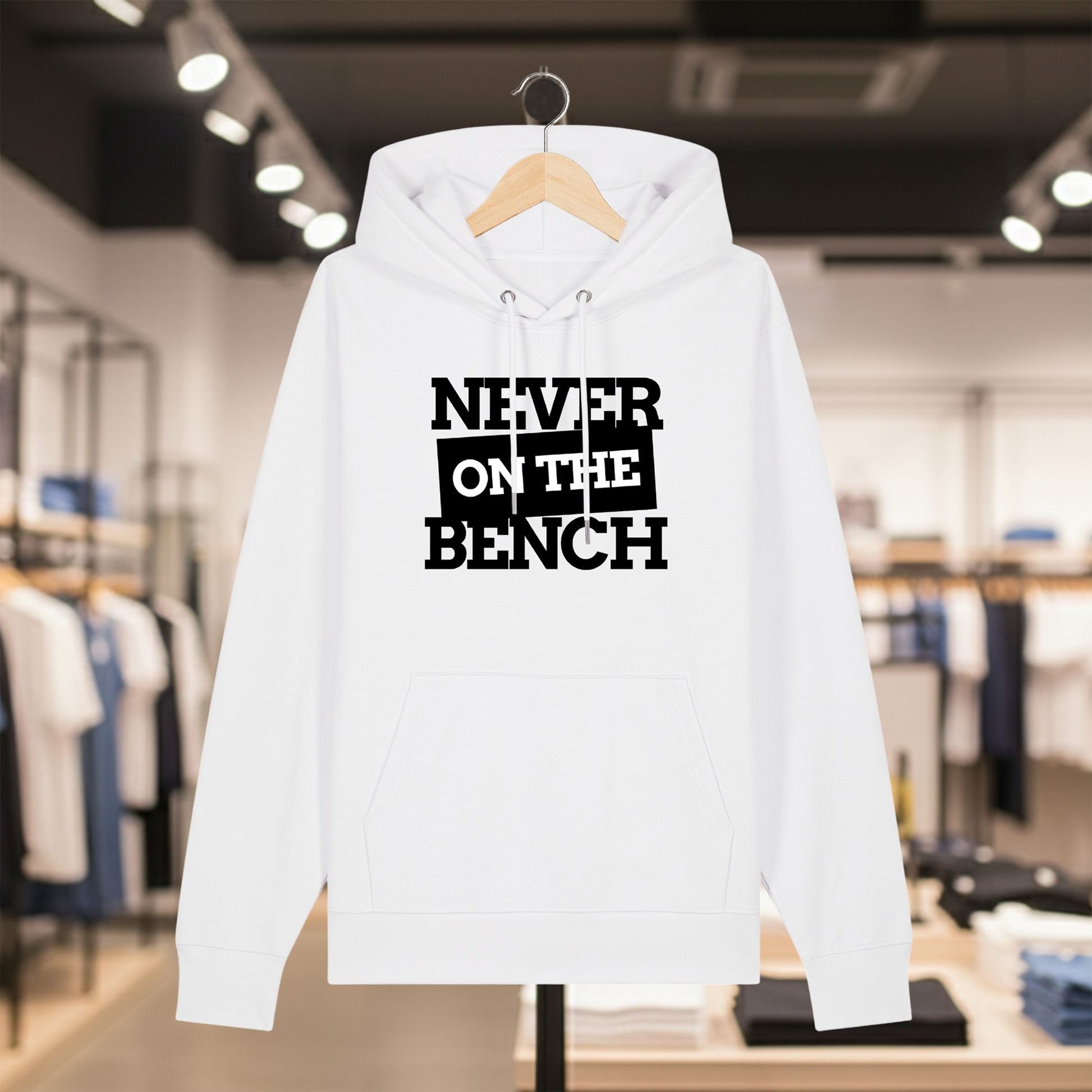 White hoodie with text NEVER ON THE BENCH on a hanger in a store setting