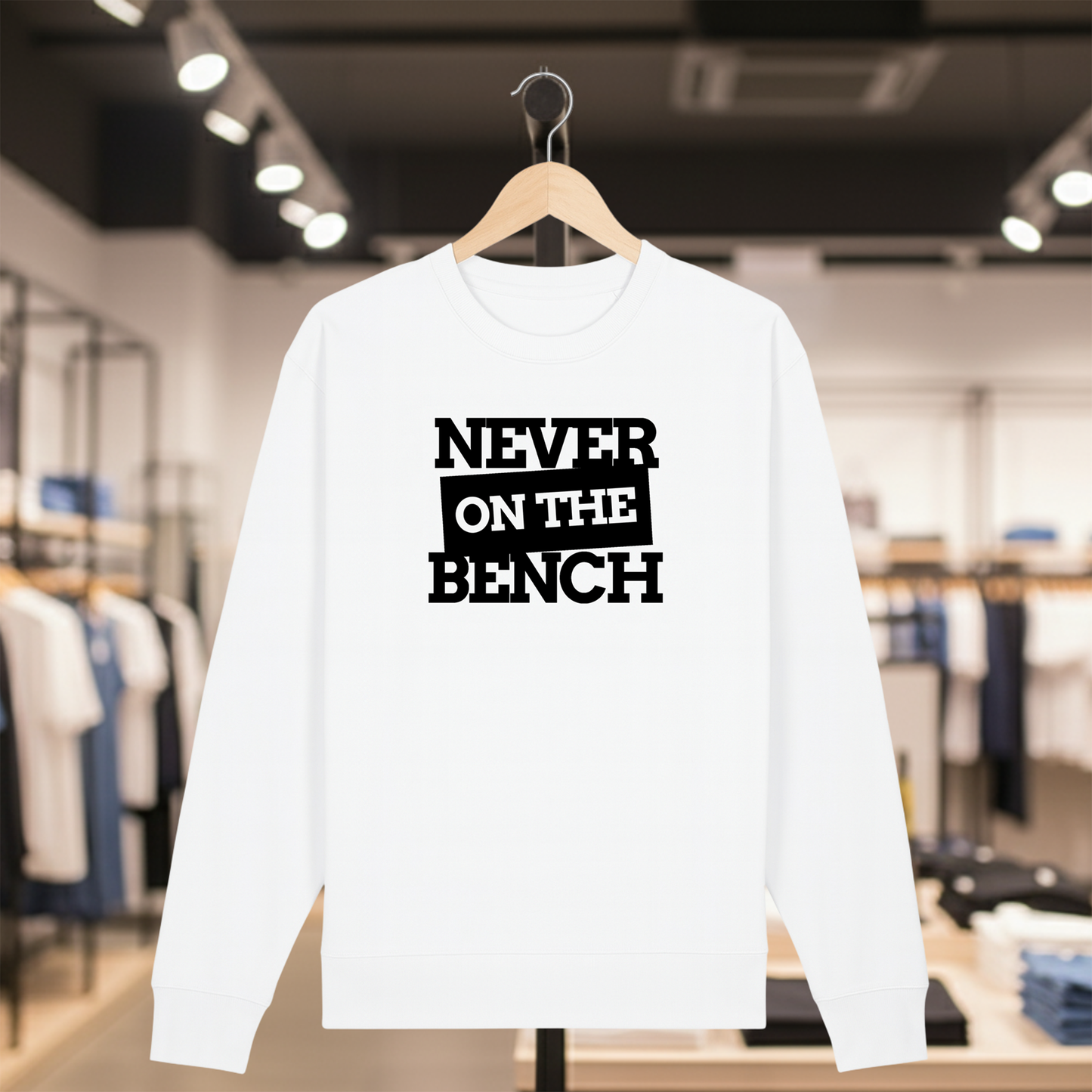 White sweatshirt with NEVER ON THE BENCH text on a hanger in a store setting