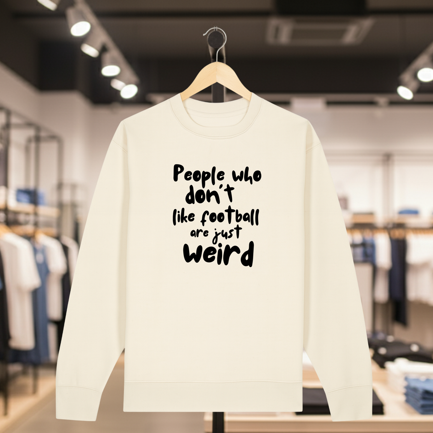 Natural sweatshirt with white text PEOPLE WHO DON'T LIKE FOOTBALL ARE JUST WEIRD on a hanger in a store setting