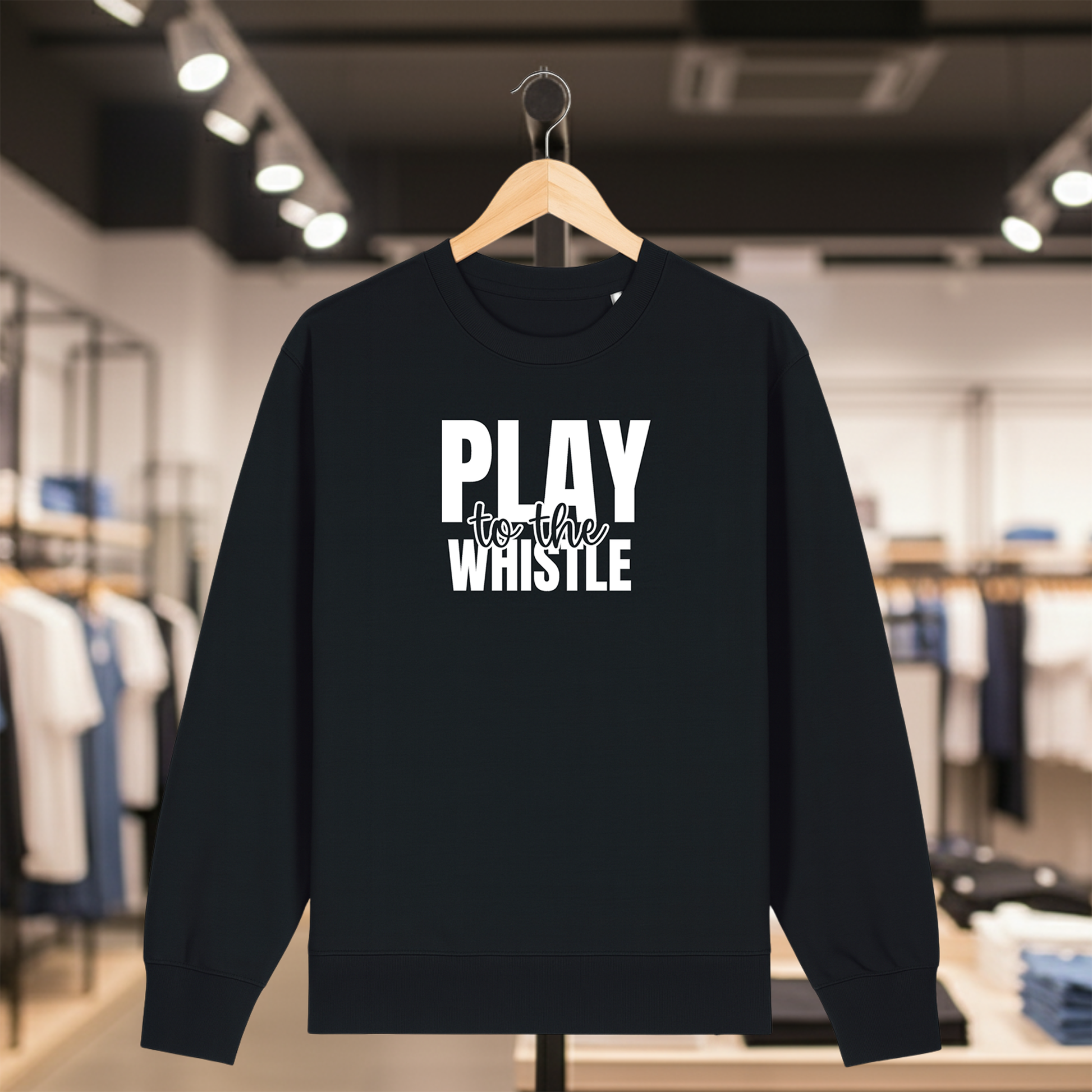 Black sweatshirt with PLAY TO THE WHISTLE text on a hanger in a store setting