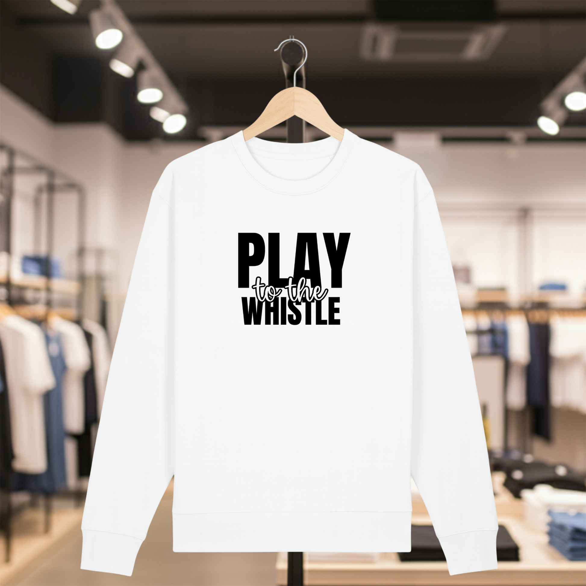 White sweatshirt with PLAY TO THE WHISTLE text on a hanger in a store setting