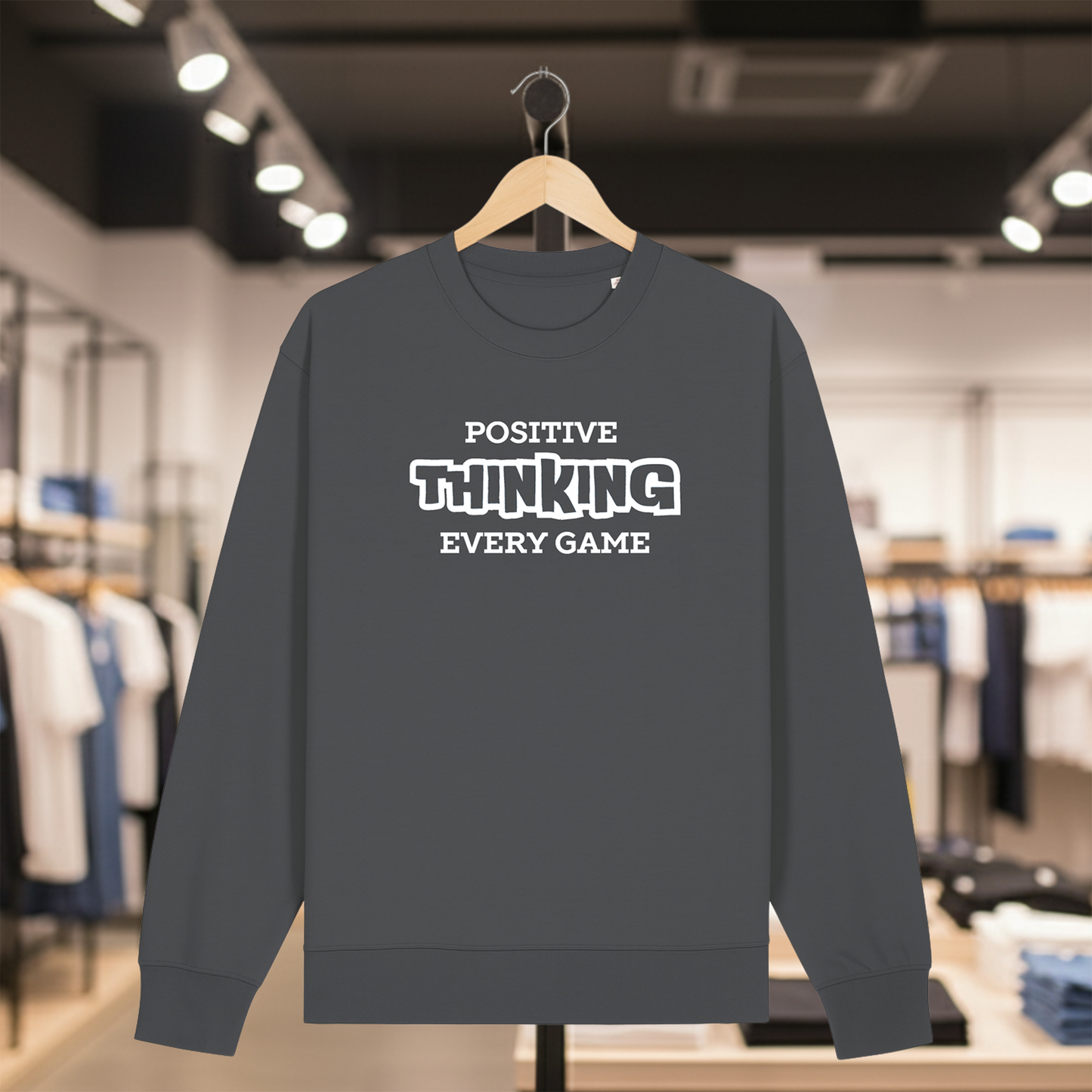 Grey sweatshirt with POSITIVE THINKING EVERY GAME text on a hanger in a store setting