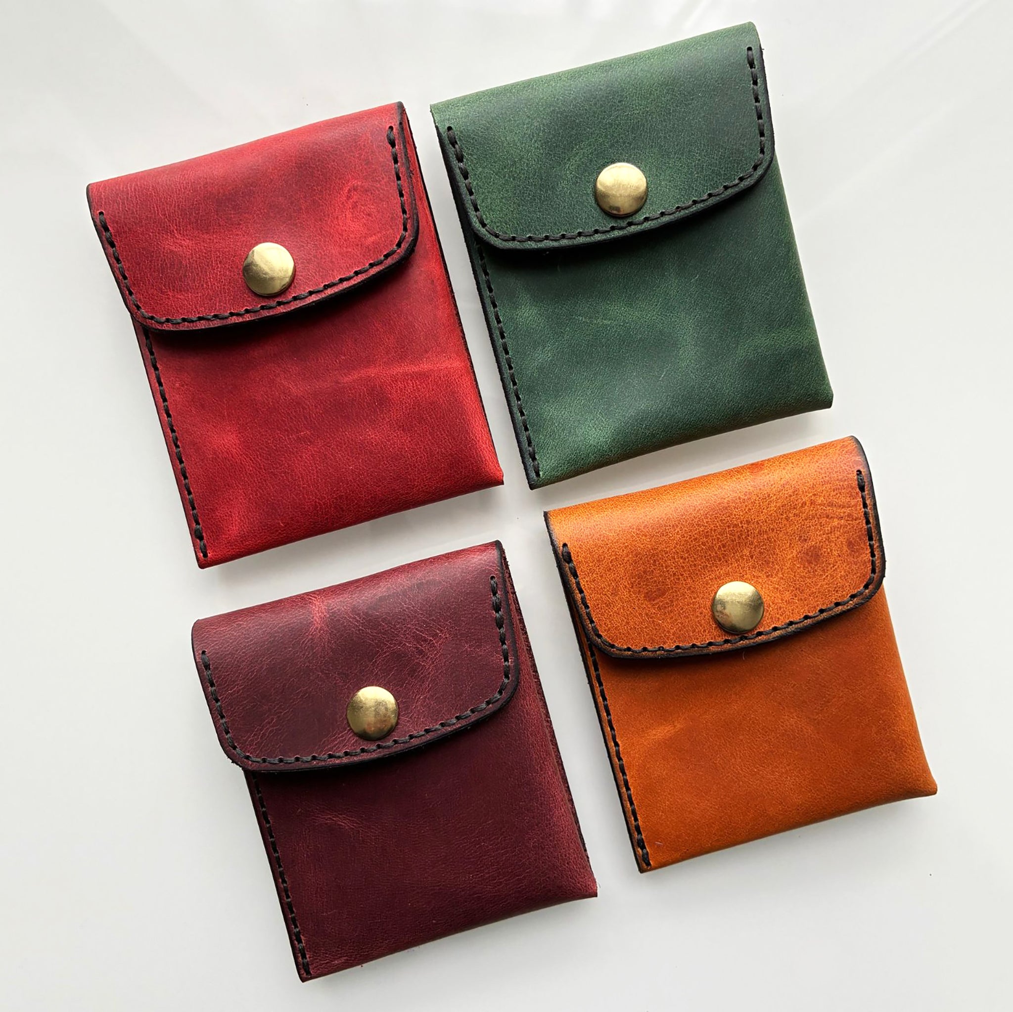 Four leather card wallets on a white background