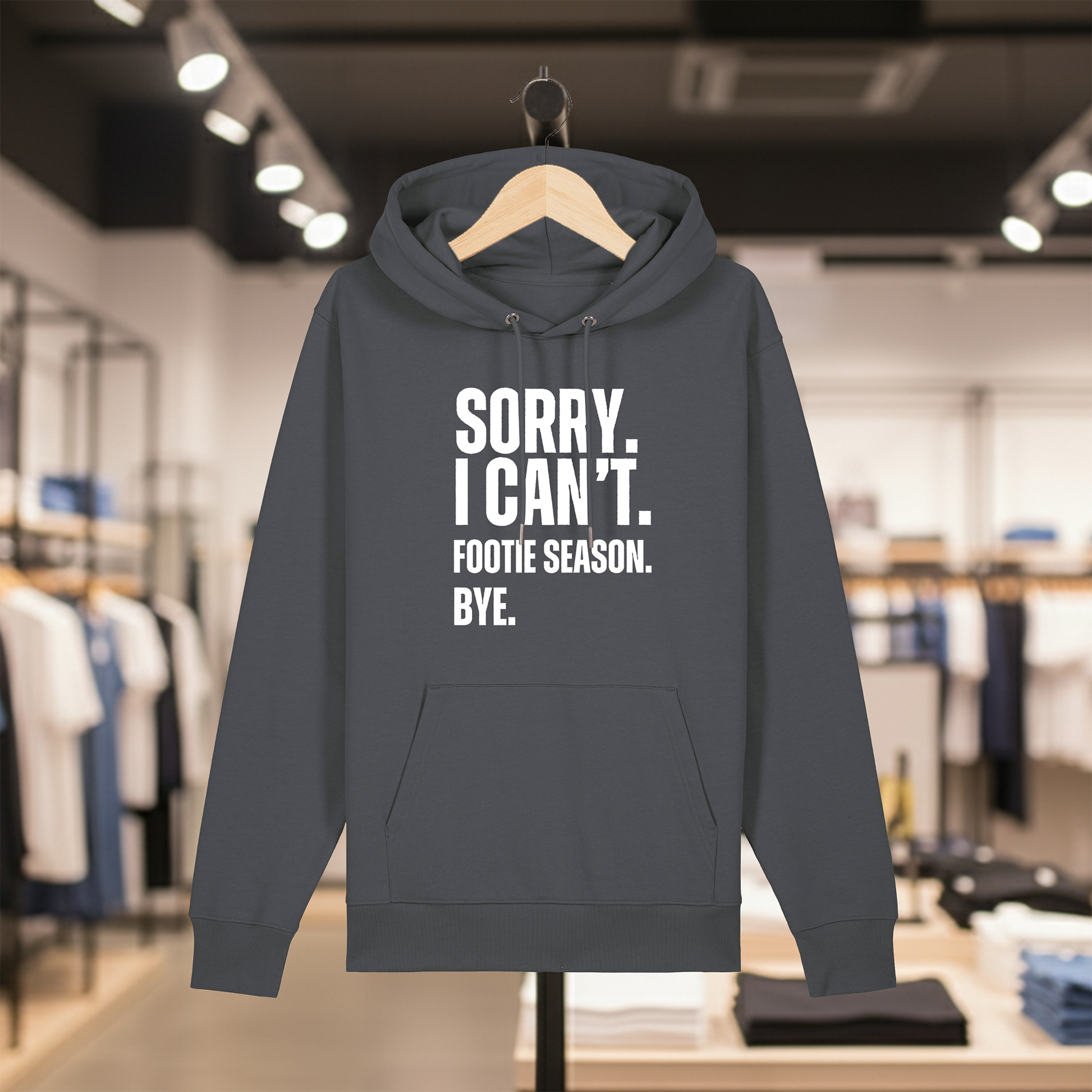Grey hoodie with text SORRY. I CAN'T. FOOTIE SEASON. BYE. on a hanger in a store setting