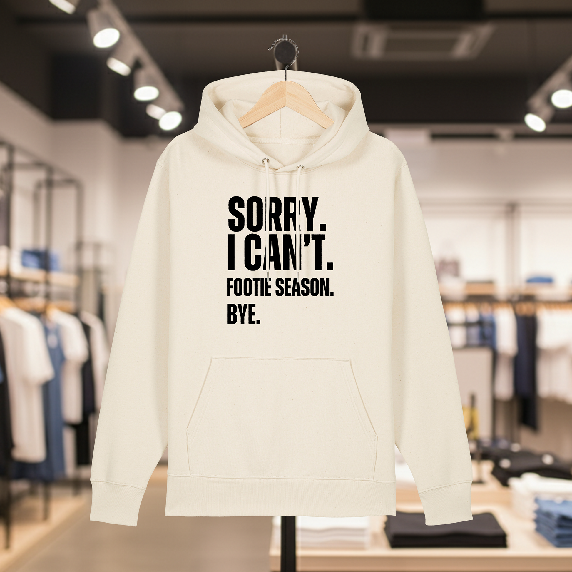 Natural hoodie with text SORRY. I CAN'T. FOOTIE SEASON. BYE. on a hanger in a store setting
