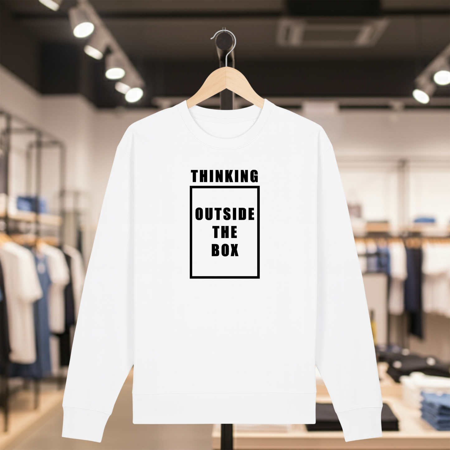 White sweatshirt with white text THINKING OUTSIDE THE BOX on a hanger in a store setting