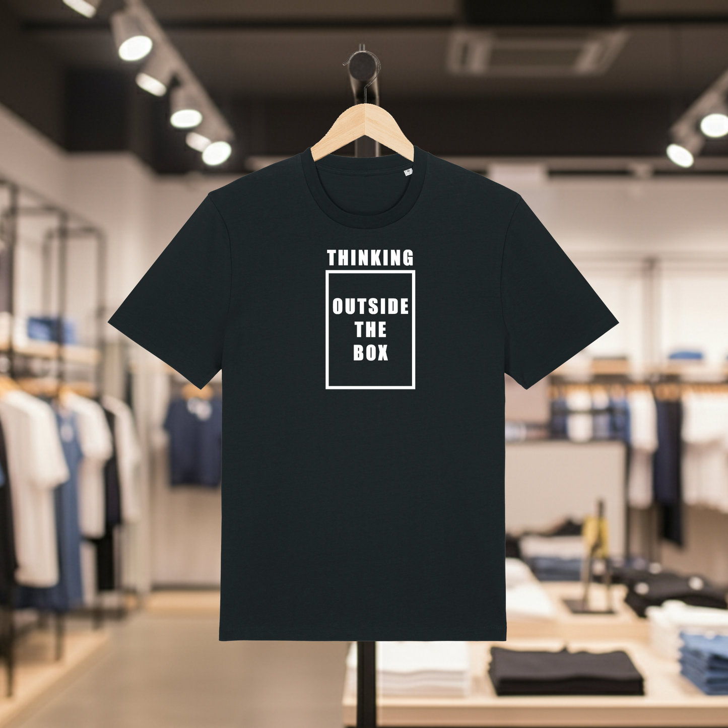 Black t-shirt with THINKING OUTSIDE THE BOX text on a hanger in a store setting