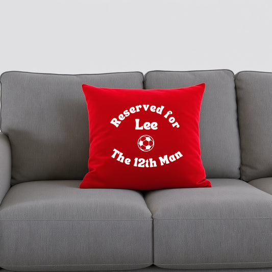 Red cushion with personalisation and a football graphic on a grey sofa
